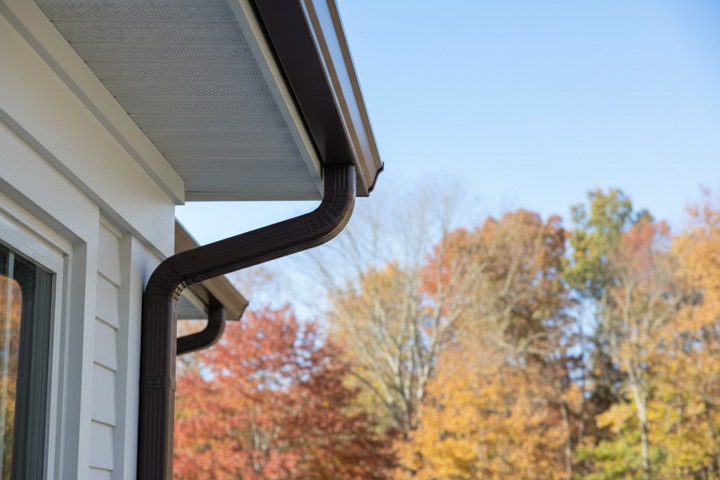 Seamless dark bronze gutter and downspout on white fascia