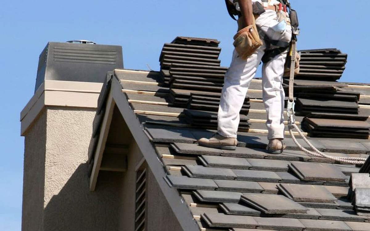 Installer working along a roof ridge where continuous ridge ventilation is fitted